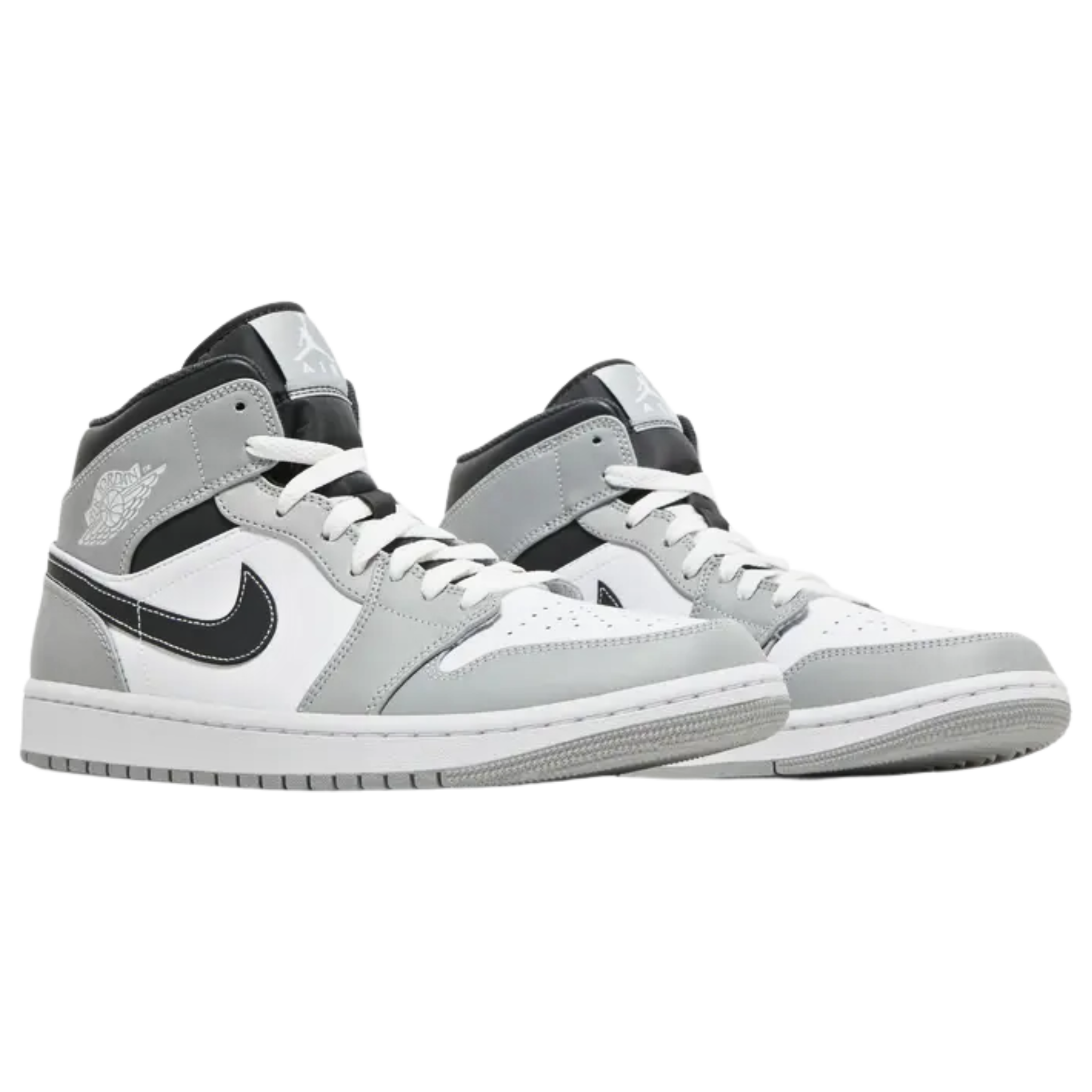 Air Jordan 1 Mid ‘Light Smoke Grey’ Anthracite featuring a smooth leather upper with a white base and light grey overlays at the forefoot and heel. The sneaker includes black accents on the mid-cut collar and Swoosh, with contrast white stitching. Additional branding includes a Jumpman icon on the woven tongue tag and a retro Wings logo on the lateral ankle. It is mounted on a durable rubber cupsole with an encapsulated Air-sole heel unit in lightweight polyurethane.